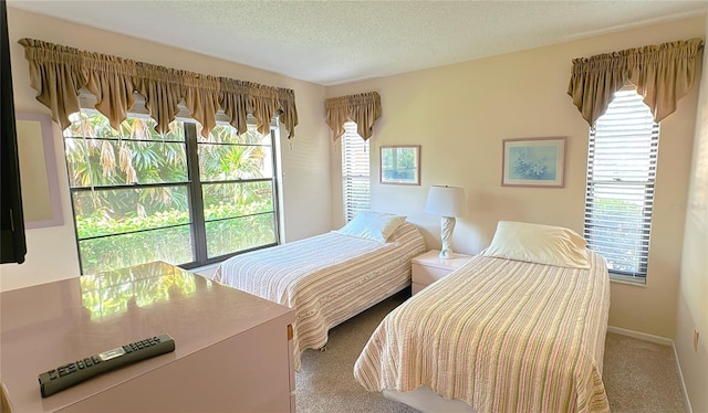 carpeted bedroom featuring a textured ceiling and multiple windows