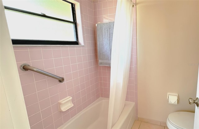 bathroom featuring tile patterned flooring, toilet, and shower / tub combo