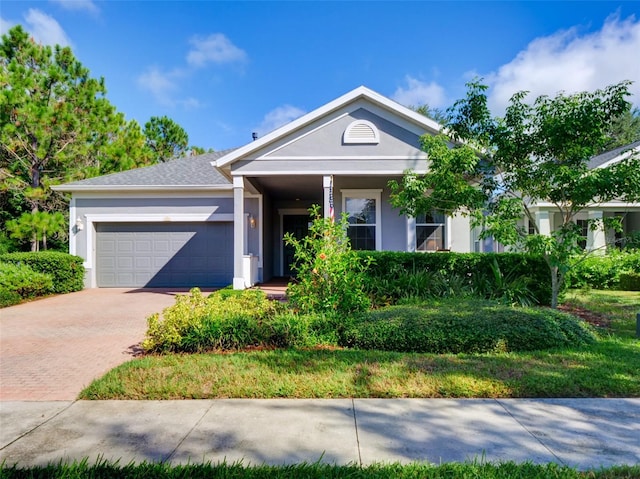 view of front facade with stucco siding, an attached garage, and decorative driveway