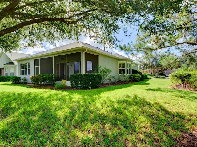 view of home's exterior with a sunroom and a lawn