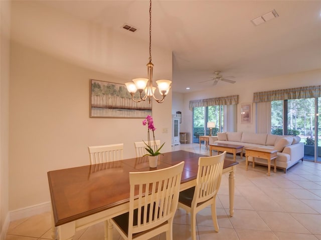 dining space with light tile patterned flooring, ceiling fan with notable chandelier, visible vents, and baseboards