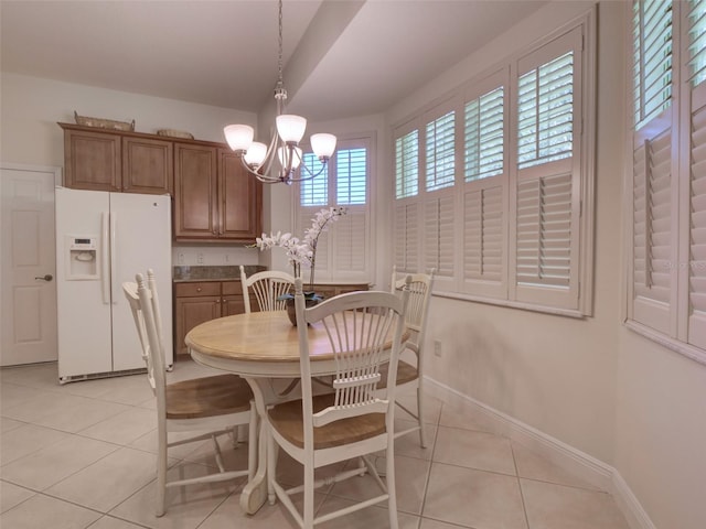 tiled dining room with a wealth of natural light and a notable chandelier