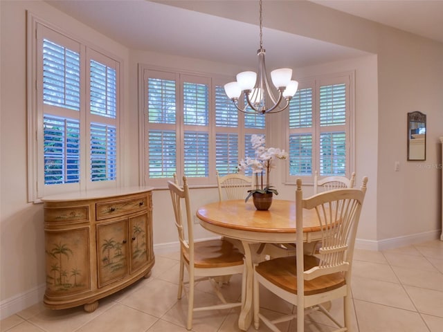 dining space with an inviting chandelier, light tile patterned floors, and baseboards