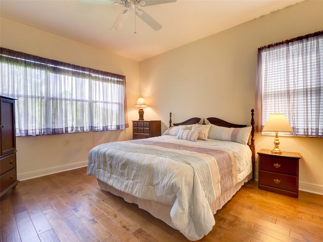 bedroom with multiple windows, ceiling fan, and light hardwood / wood-style flooring