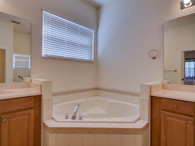 full bathroom with visible vents, a shower stall, vanity, and a garden tub