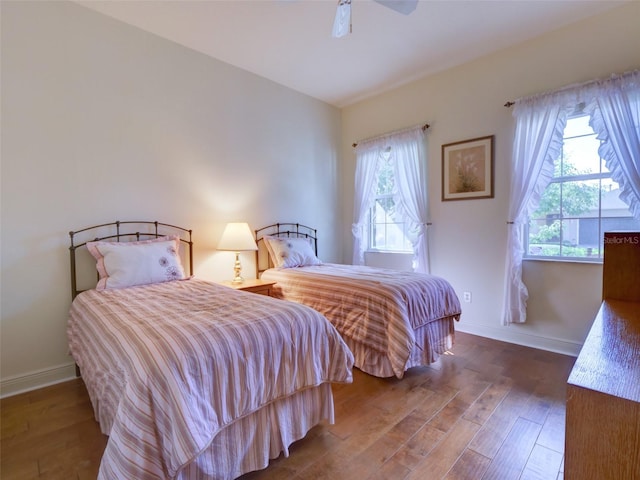 bedroom with wood finished floors, baseboards, and ceiling fan