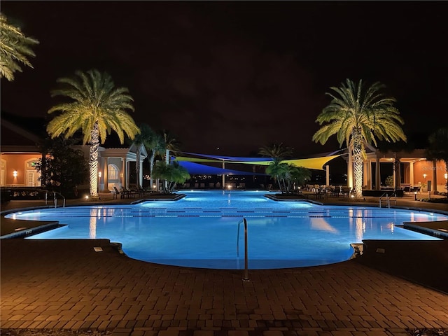 pool at twilight with a patio area