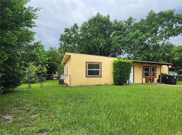 exterior space featuring cooling unit and a front yard