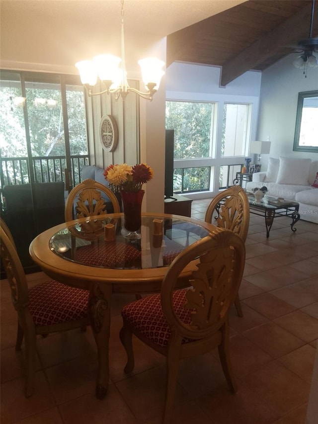 tiled dining room featuring a wealth of natural light, lofted ceiling with beams, and ceiling fan with notable chandelier