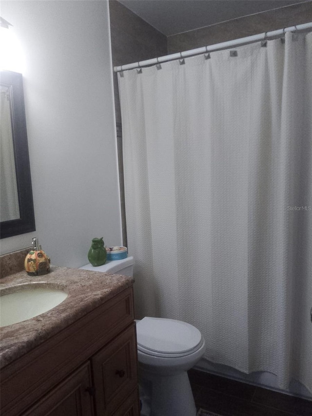 bathroom with a shower with shower curtain, vanity, and toilet