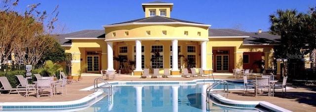 back of property featuring a patio area and a community pool