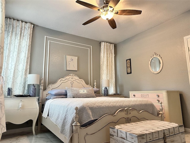 bedroom with ceiling fan and a textured ceiling