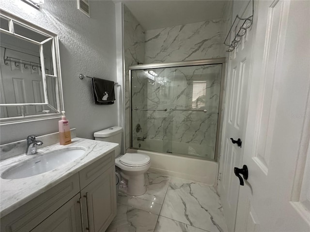 full bathroom with enclosed tub / shower combo, vanity, and toilet