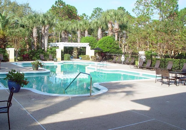 view of swimming pool with a hot tub and a patio area