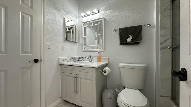 bathroom with an enclosed shower, vanity, and toilet