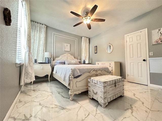 bedroom with ceiling fan and a textured ceiling