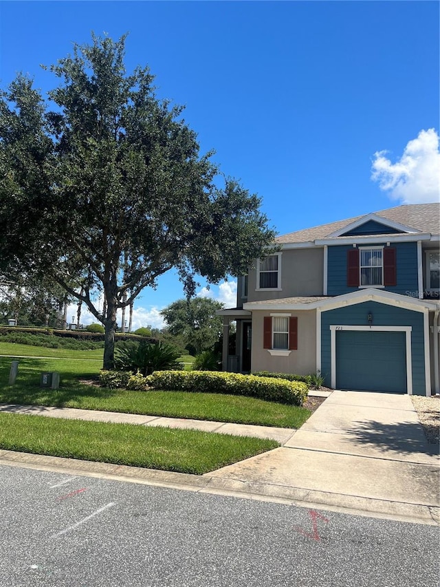 view of front of property featuring a front yard and a garage