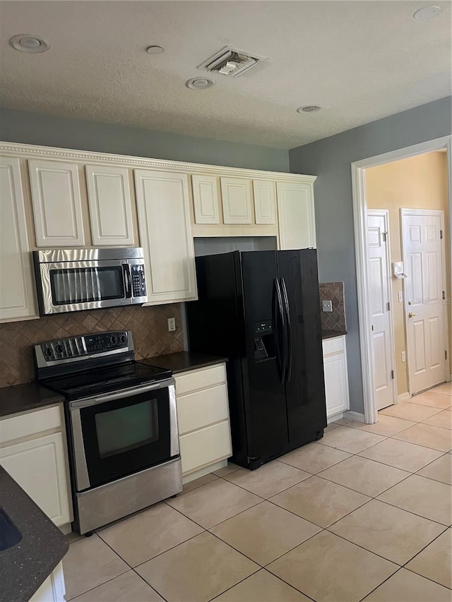 kitchen with light tile patterned floors, backsplash, and stainless steel appliances