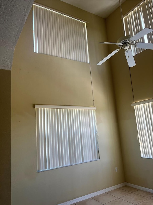 unfurnished room with ceiling fan and light tile patterned floors