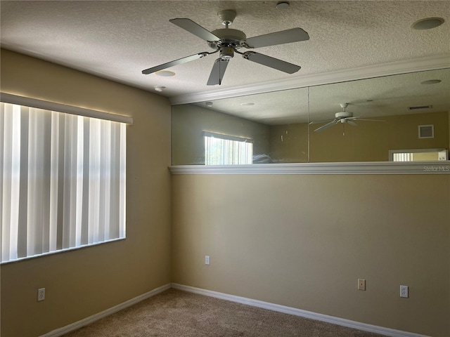 unfurnished room with a textured ceiling, ceiling fan, and carpet floors