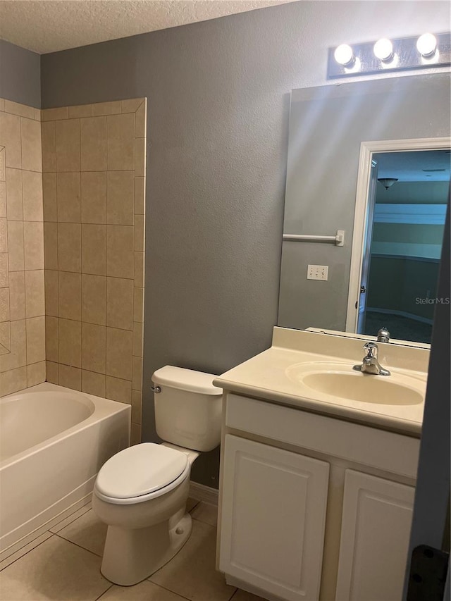 full bathroom with tile patterned floors, toilet, tiled shower / bath combo, vanity, and a textured ceiling