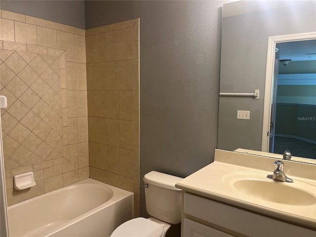 full bathroom featuring tiled shower / bath, toilet, and vanity