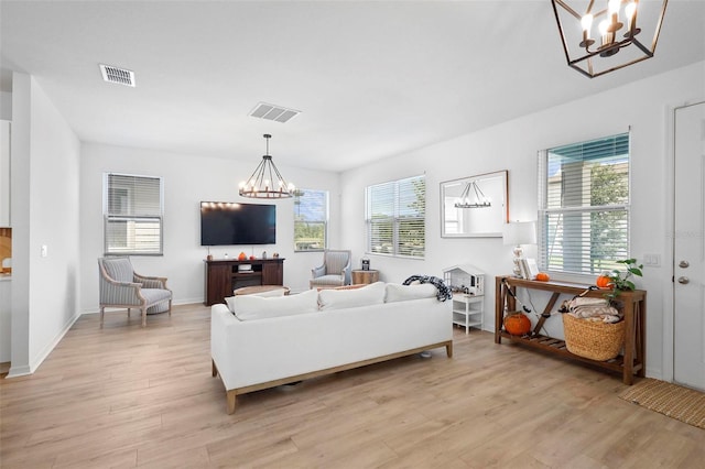 living room with a chandelier and light hardwood / wood-style flooring