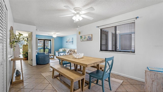 tiled dining space featuring a textured ceiling and ceiling fan