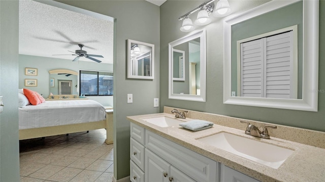 bathroom with vanity, a textured ceiling, ceiling fan, and tile patterned floors