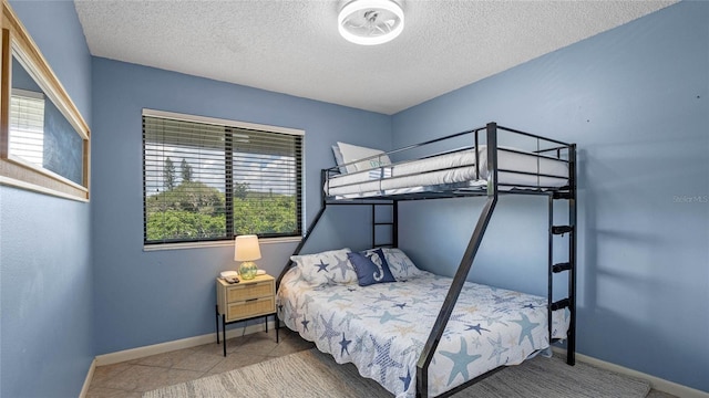 tiled bedroom with multiple windows and a textured ceiling