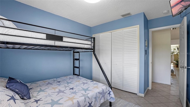 tiled bedroom featuring a textured ceiling