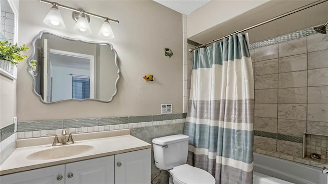 full bathroom featuring shower / bath combo with shower curtain, tile walls, toilet, and vanity