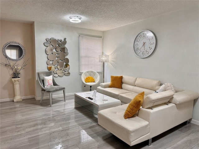 living area with a textured ceiling and baseboards