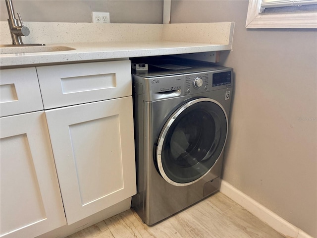 laundry room featuring washer / clothes dryer, a sink, baseboards, and laundry area