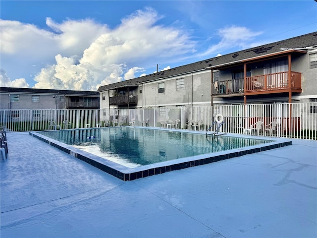 view of swimming pool featuring fence