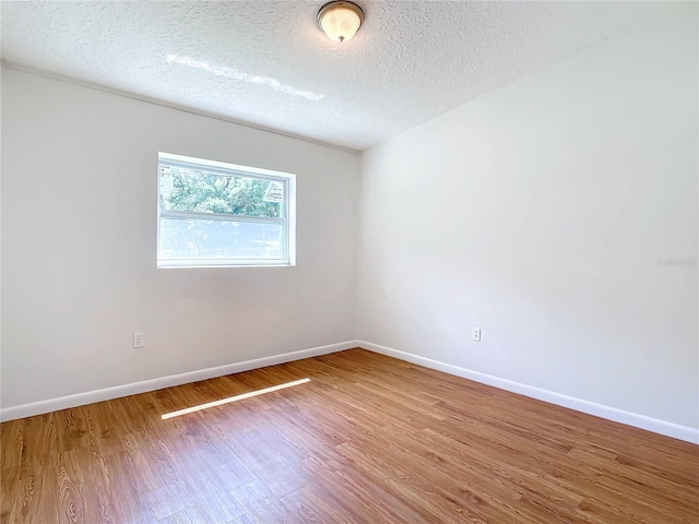 spare room with hardwood / wood-style flooring and a textured ceiling