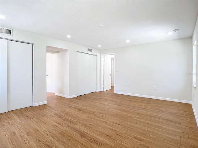 spare room featuring a textured ceiling and light hardwood / wood-style flooring