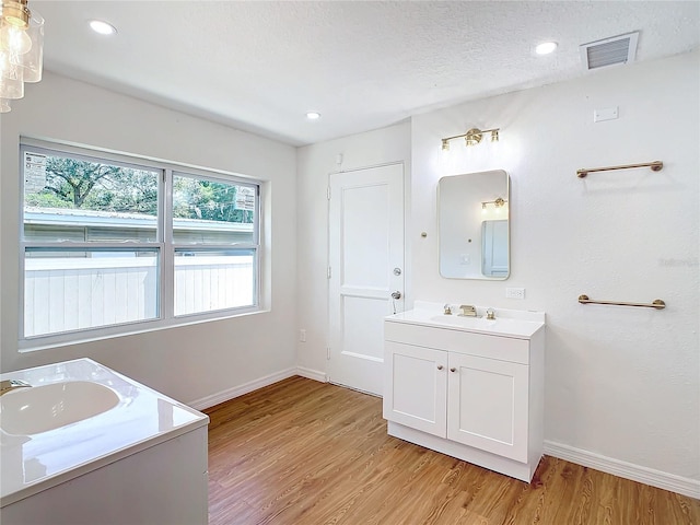 bathroom featuring a textured ceiling, vanity, and wood-type flooring