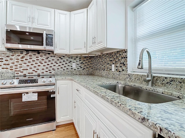 kitchen featuring white cabinetry, appliances with stainless steel finishes, sink, and tasteful backsplash