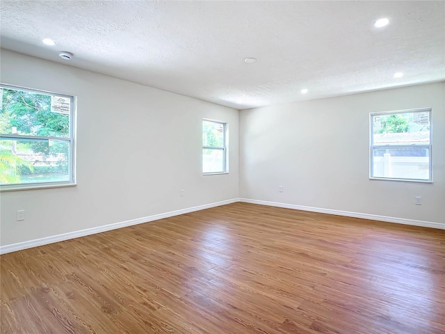 spare room featuring a textured ceiling and hardwood / wood-style flooring