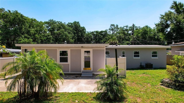 view of front of property with central air condition unit, a front yard, and a patio area