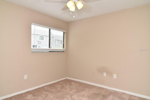 spare room featuring carpet flooring, ceiling fan, and a textured ceiling