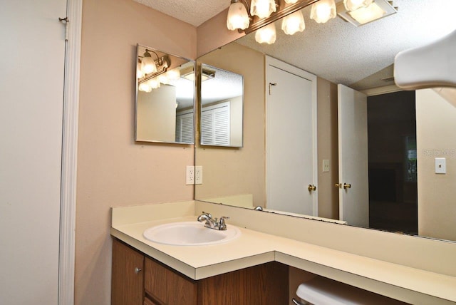 bathroom with a textured ceiling and vanity