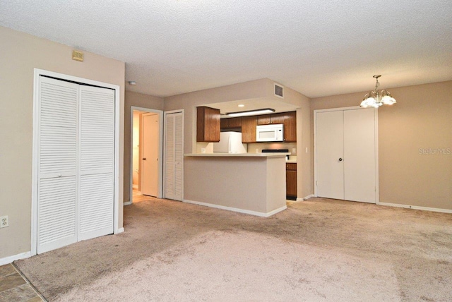 unfurnished living room featuring light colored carpet, a chandelier, and a textured ceiling