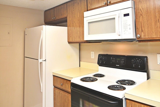 kitchen with a textured ceiling and white appliances