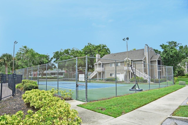 view of sport court featuring a lawn