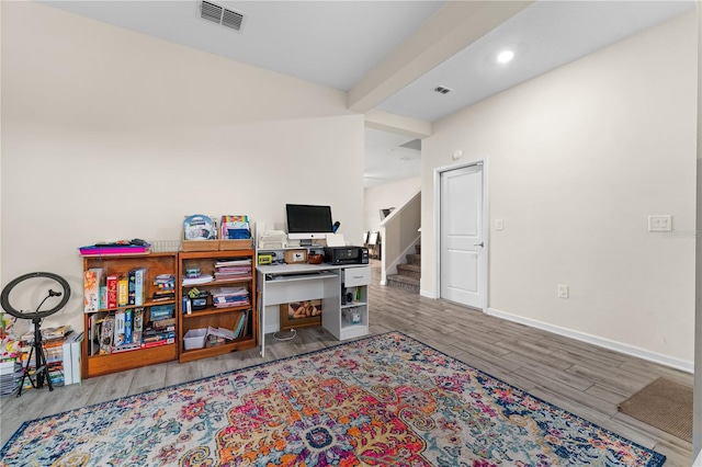 home office featuring hardwood / wood-style floors and beamed ceiling