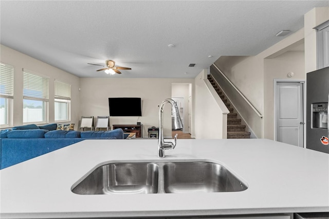 kitchen with ceiling fan, a textured ceiling, and sink