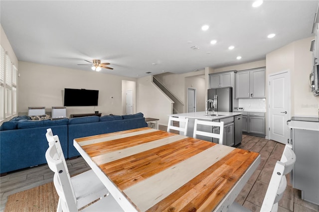 dining area featuring sink, ceiling fan, and light hardwood / wood-style floors