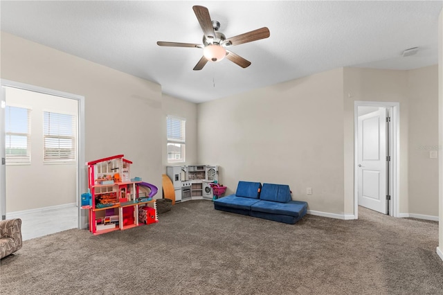 game room with a healthy amount of sunlight, ceiling fan, and carpet